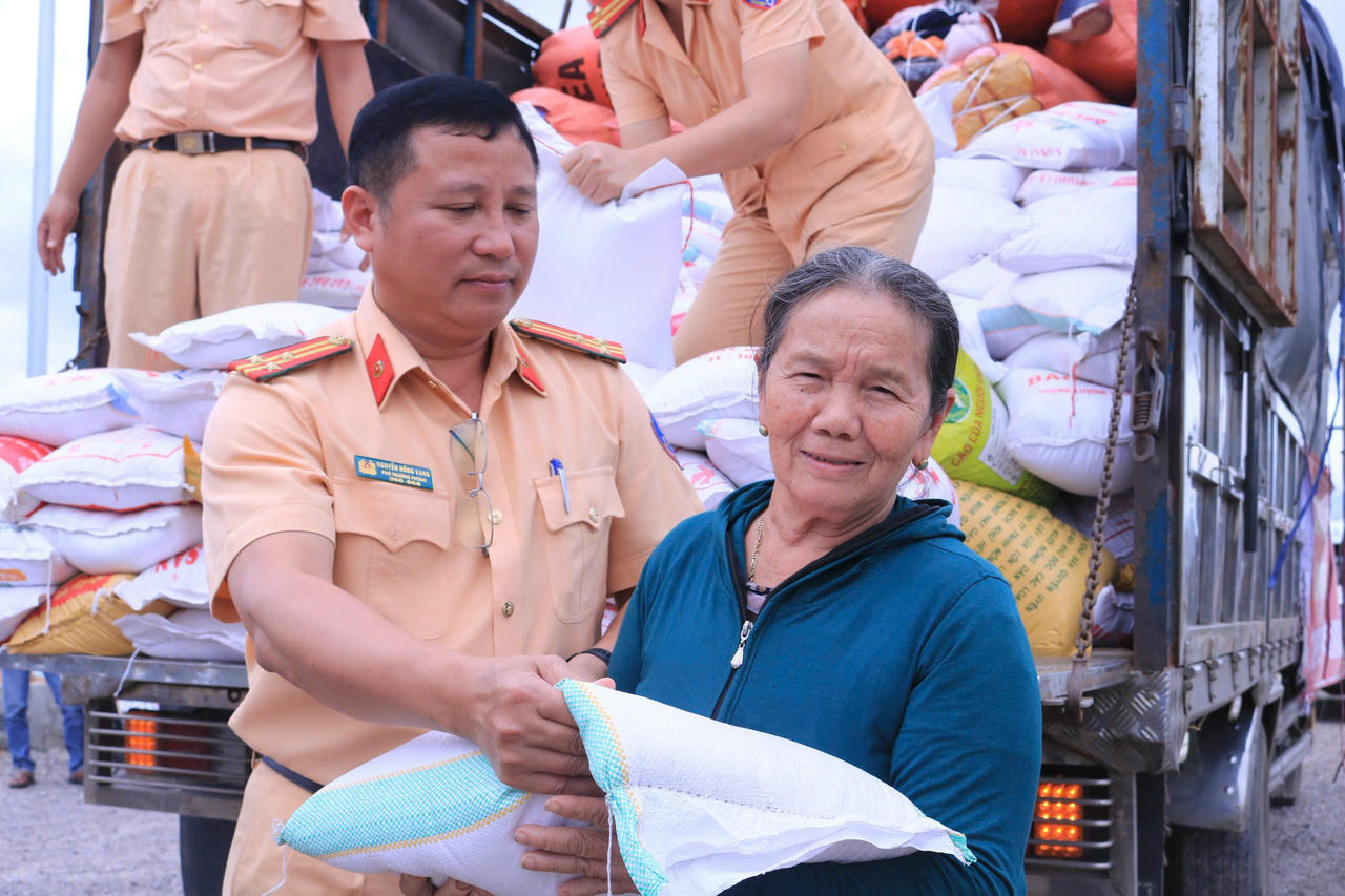 Thượng tá Nguyễn Hồng Vang – Phó Trưởng phòng CSGT Gia Lai trao từng bao gạo cho người dân vùng lũ Tuy Phước Đông.
