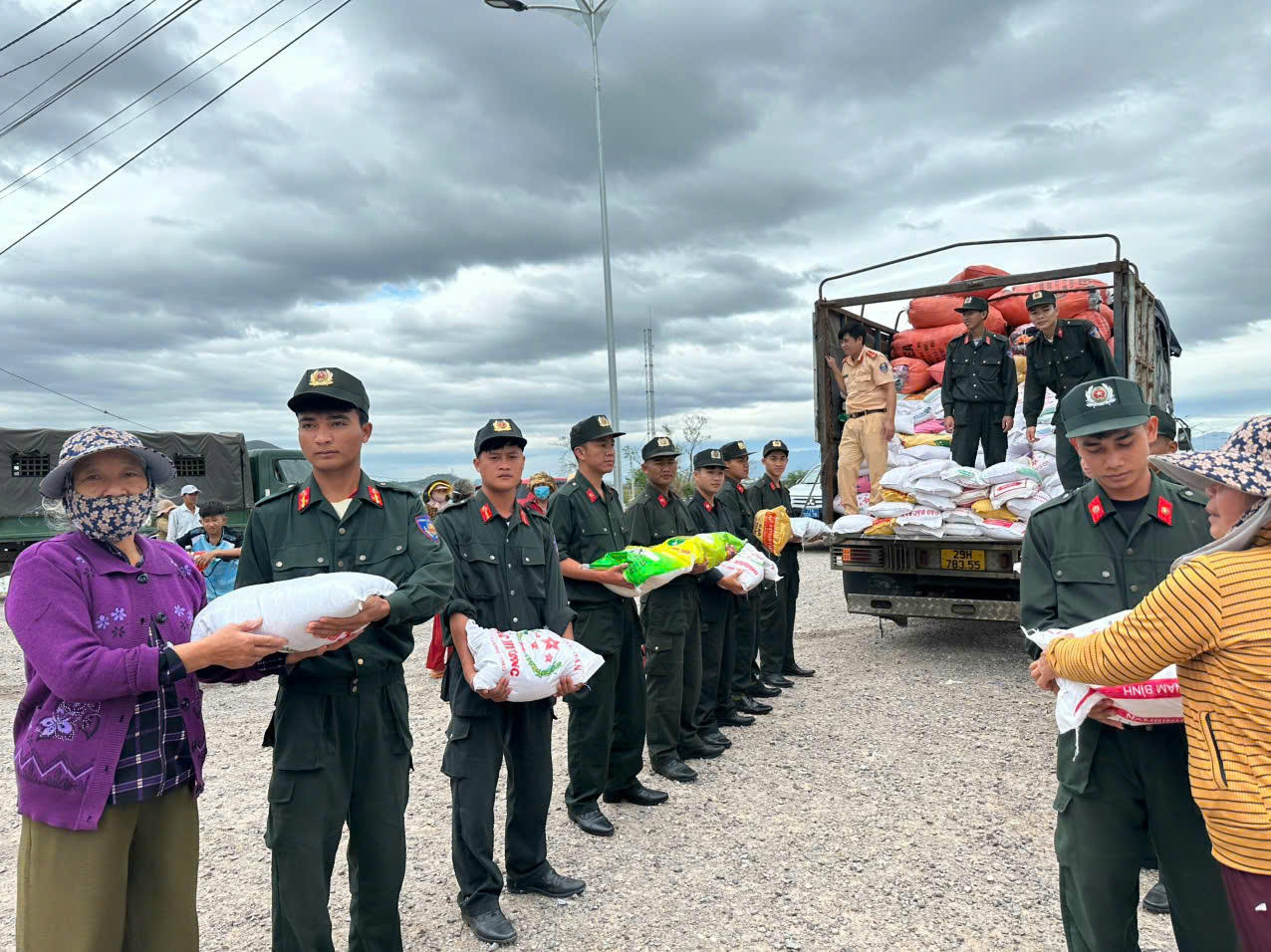 Các chiến sĩ chuyền tay nhau vận chuyển gạo xuống xe nhanh chóng đưa đến các hộ dân đang chờ đợi.
