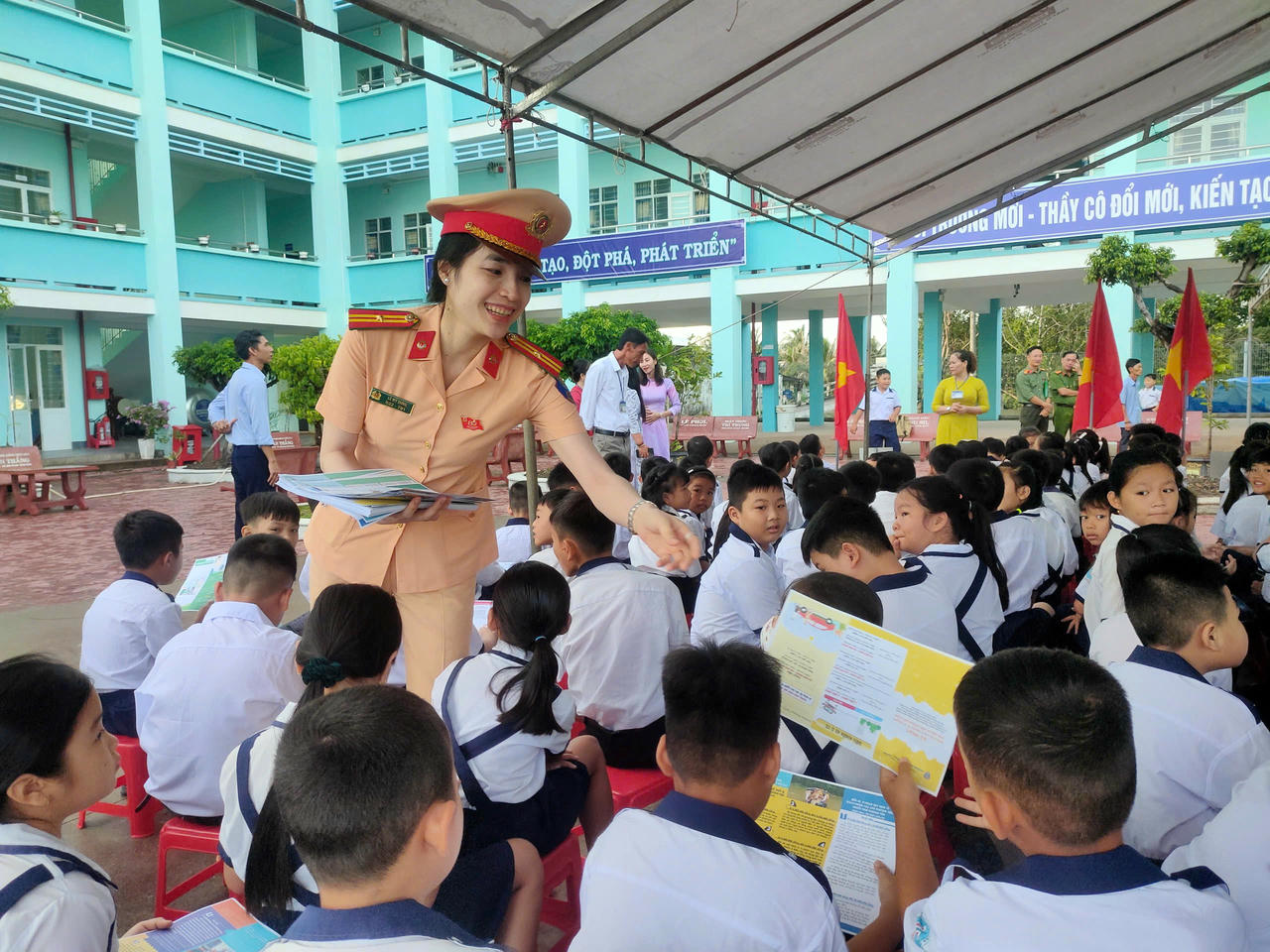 Phát tờ rơi tuyên truyền, hướng dẫn kỹ năng tham gia giao thông an toàn cho học sinh.