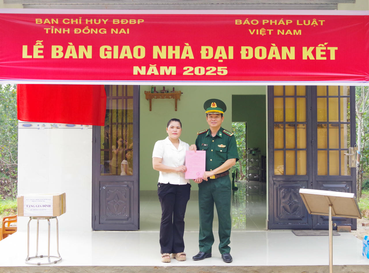 Bà Mùng Thị Thu - mẹ của Hạ sĩ Hoàng Văn Hùng nhận Quyết định bàn giao nhà Đại đoàn kết (ảnh: Cao Thi)