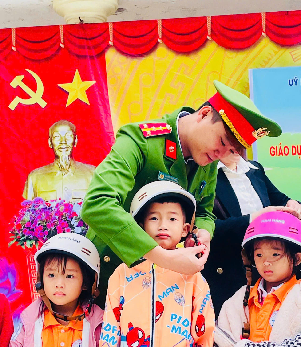 Các em được hướng dẫn cách đội mũ đúng quy cách, cài quai đúng chuẩn để đảm bảo an toàn khi tham gia giao thông