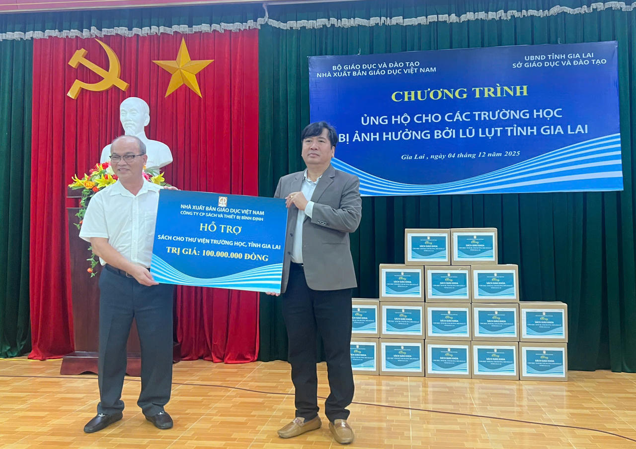 Ông Nguyễn Quốc Huy - Giám đốc công ty CP Sách và Thiết bị Bình Định (trái) trao biển tặng cho lãnh đạo Sở GD-ĐT tỉnh Gia Lai