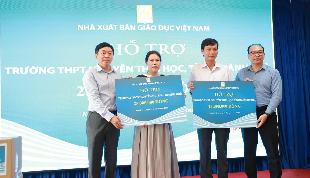 Ông Ông Thừa Phú (bìa trái) – Giám đốc NXBGDVN tại TP. Đà Nẵng và ông Đặng Thanh Hải Phó Tổng Giám đốc NXBGDVN  (bìa phải) trao biển tượng trưng số tiền hỗ trợ cho Trường THPT Nguyễn Thái Học và Trường THCS Nguyễn Du
