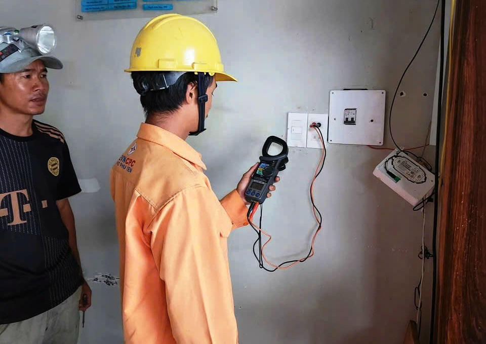 Cán bộ ngành điện hỗ trợ người dân kiểm tra hệ thống điện sau công tơ.