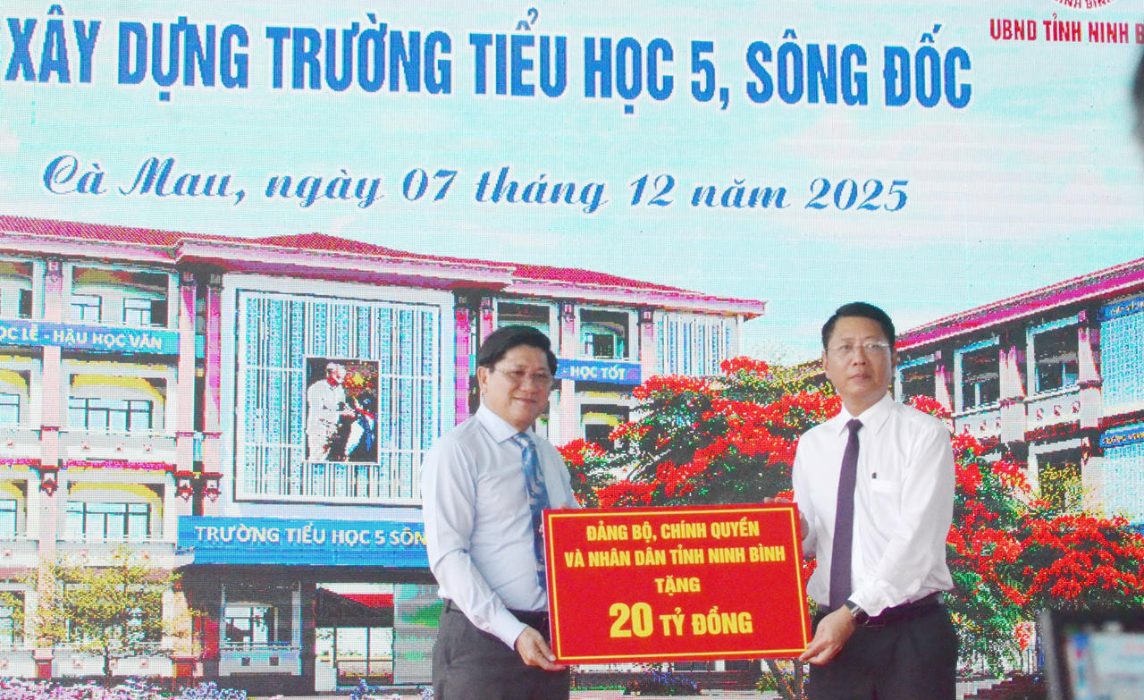 Lãnh đạo tỉnh Ninh Bình (bên phải) trao bảng tượng trưng hỗ trợ 20 tỷ đồng cho tỉnh Cà Mau xây dựng, nâng cấp Trường Tiểu học 5 Sông Đốc.