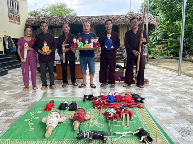 Nghệ nhân Ma Quang Nhanh (đứng thứ 2 từ trái sang) cùng các thành viên phường rối cạn Thẩm Rộc, xã Bình Yên chuẩn bị con rối trước khi biểu diễn