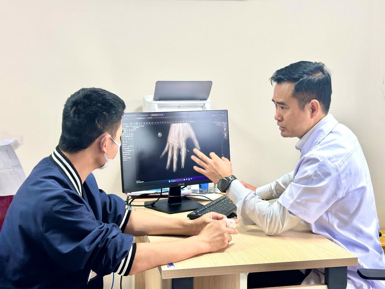 TS.BS Vũ Trung Trực - Phó Trưởng khoa Phẫu thuật Hàm mặt, Tạo hình và Thẩm mỹ thăm khám sau phẫu thuật cho người bệnh