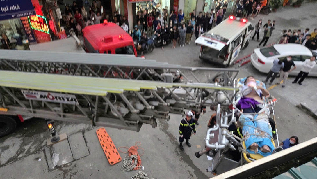 Lực lượng Cảnh sát PCCC&CNCH đưa nạn nhân từ trên cao xuống vị trí an toàn bằng xe thang bàn giao cho lực lượng y tế. (Ảnh: CACC).