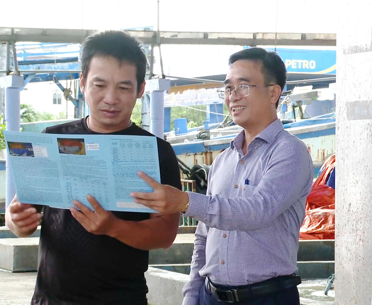 Ông Phạm Văn Mười (bên phải) - Phó Giám đốc Sở Nông nghiệp và Môi trường Cà Mau, hướng dẫn, tuyên truyền chống khai thác IUU cho ngư dân.