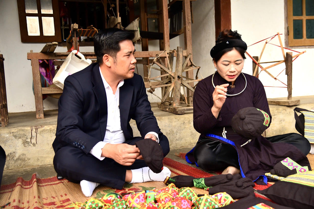 Chị Hứa Thị Hoãn, Chủ nhiệm CLB Hát Then - Đàn Tính của xã Nam Cường chia sẻ về các cách tạo ra các sản phẩm thổ cẩm do chị làm ra. (Ảnh: Thanh Tùng)