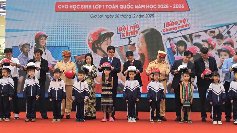 Các đại biểu trao tặng mũ bảo hiểm cho các em học sinh lớp 1 trường Tiểu học Lê Quý Đôn