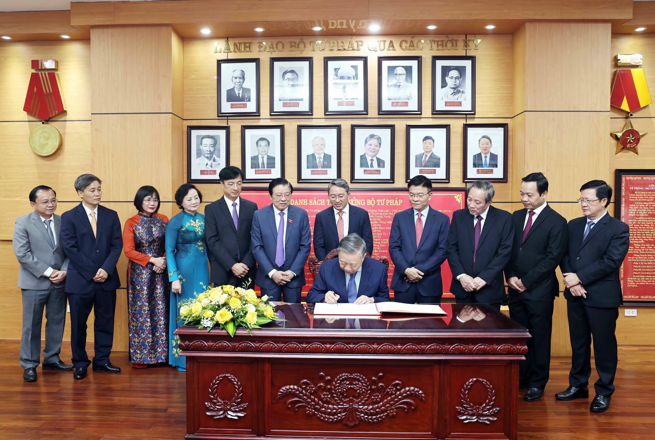 Tổng Bí thư Tô Lâm ghi lưu bút tại Phòng Truyền thống Bộ Tư pháp. (Ảnh: TTXVN)