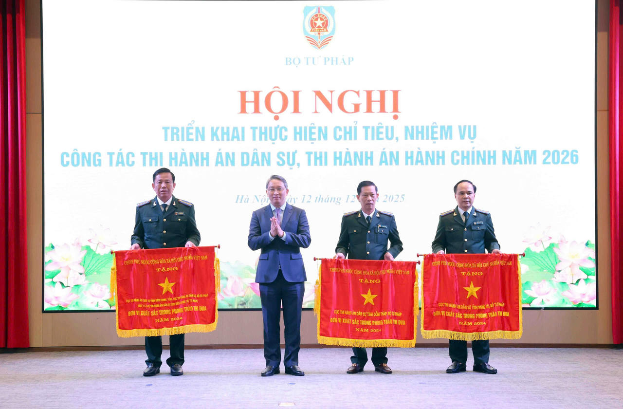 Bộ trưởng Bộ Tư pháp Nguyễn Hải Ninh đã tặng Cờ thi đua của Chính phủ cho 3 tập thể. (Ảnh: Phương Mai)