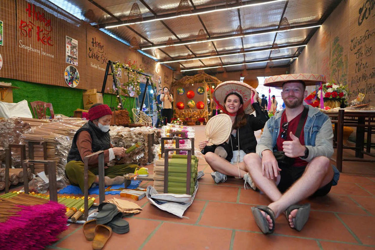 Khách du lịch quốc tế thích thú với trải nghiệm
tại làng nghề. (Ảnh: Linh Tâm)