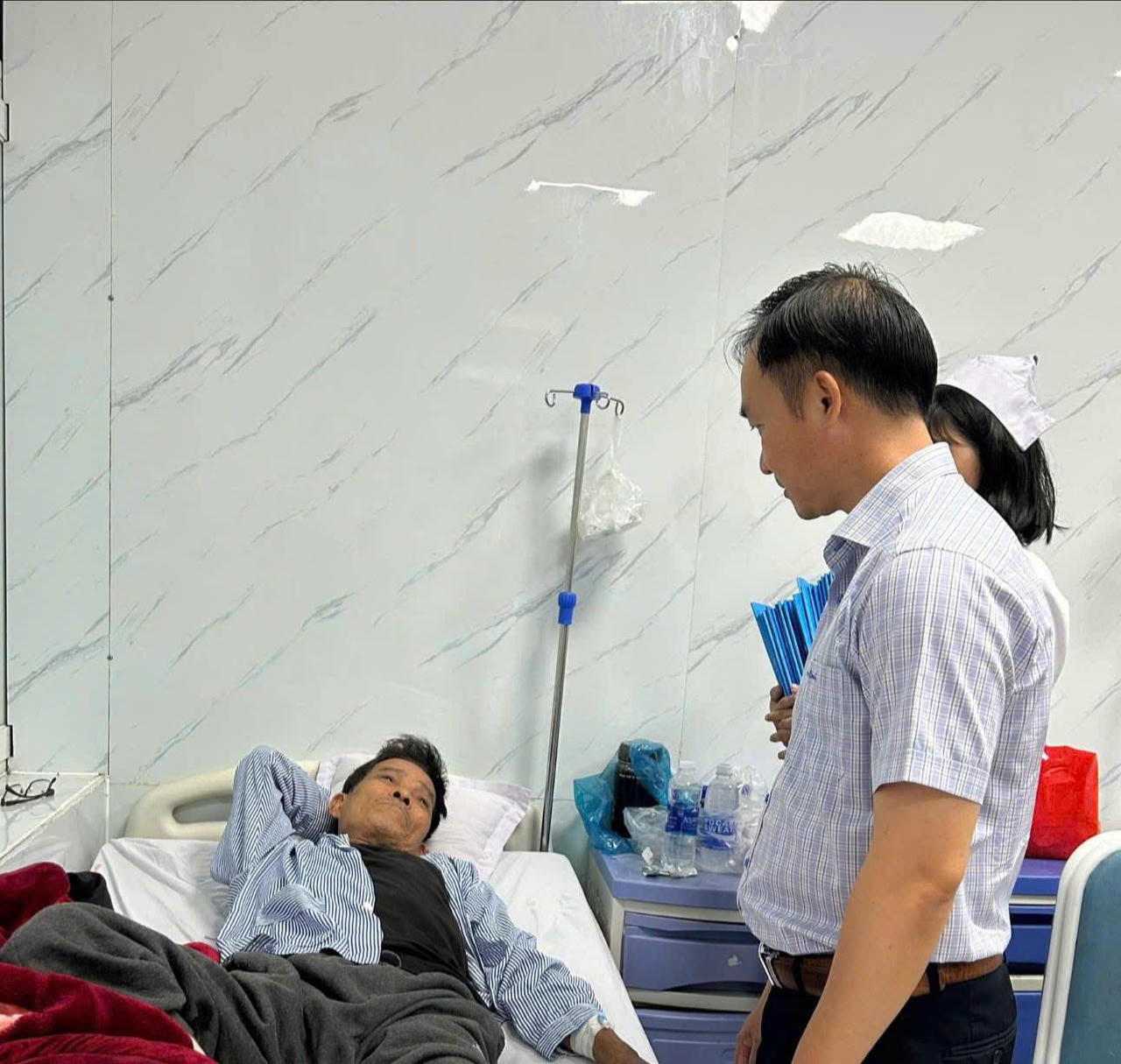 Các lực lượng chức năng thăm hỏi nạn nhân bị ngộ độc phải nhập viện điều trị sau khi ăn bánh mì Hồng Vân