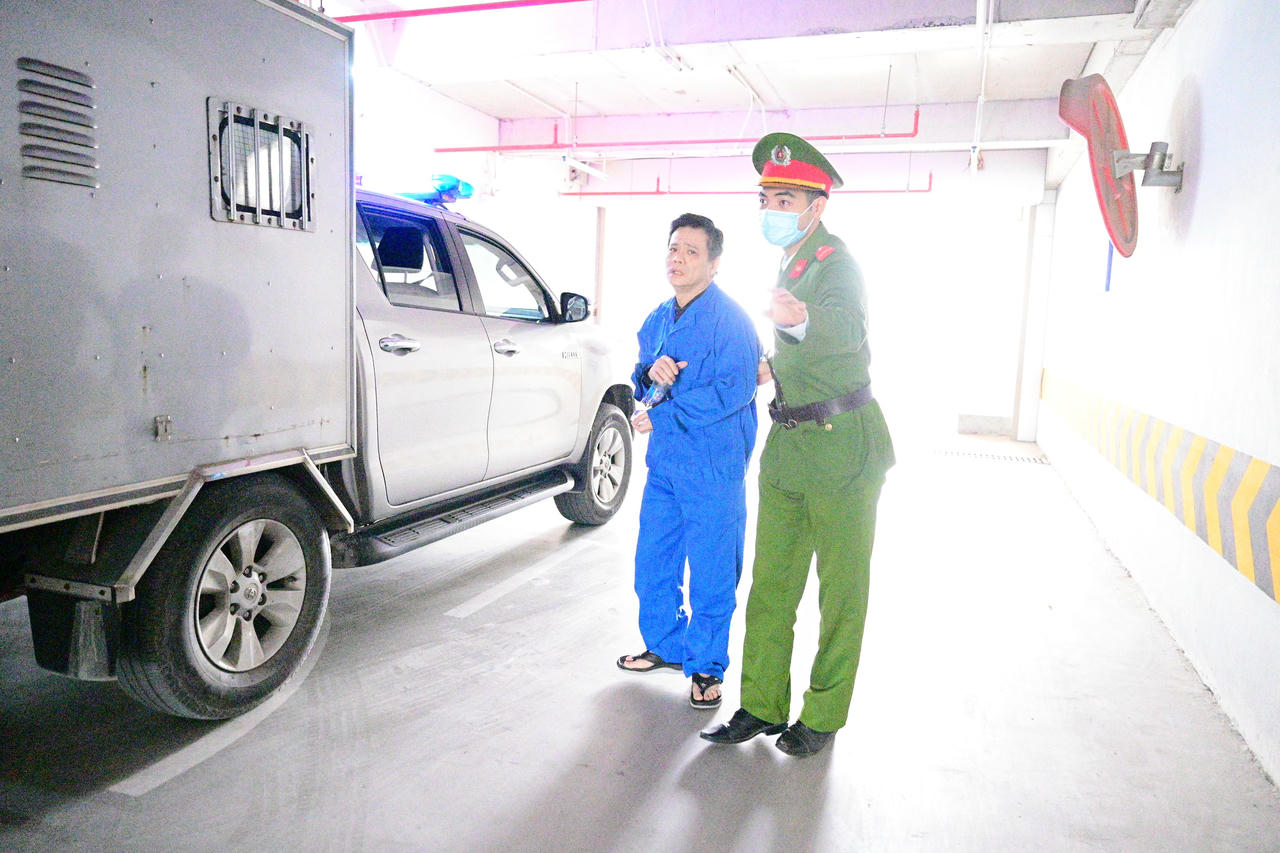 Dẫn giải bị cáo vào phòng xét xử.