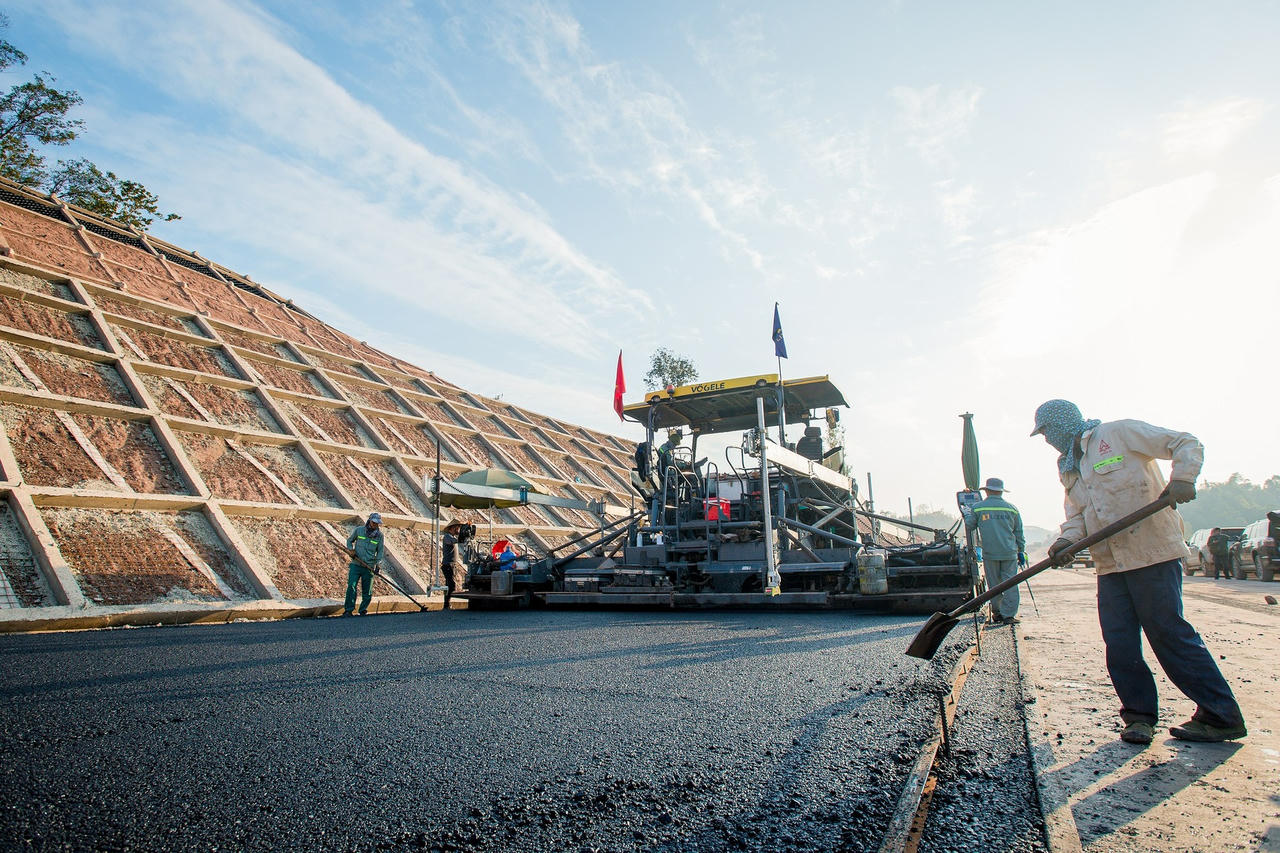 Riêng dây chuyền thảm nhựa tại phân đoạn này hiện huy động 15 thiết bị và 30 nhân công, làm việc từ 7h - 20h mỗi ngày. Trong điều kiện thời tiết thuận lợi, nhà thầu thi công huy động xe chở bê tông nhựa từ trạm trộn cùng dây chuyền thảm hiện đại và nhiều thiết bị lu lèn, tiến hành thảm bê tông nhựa mặt đường.