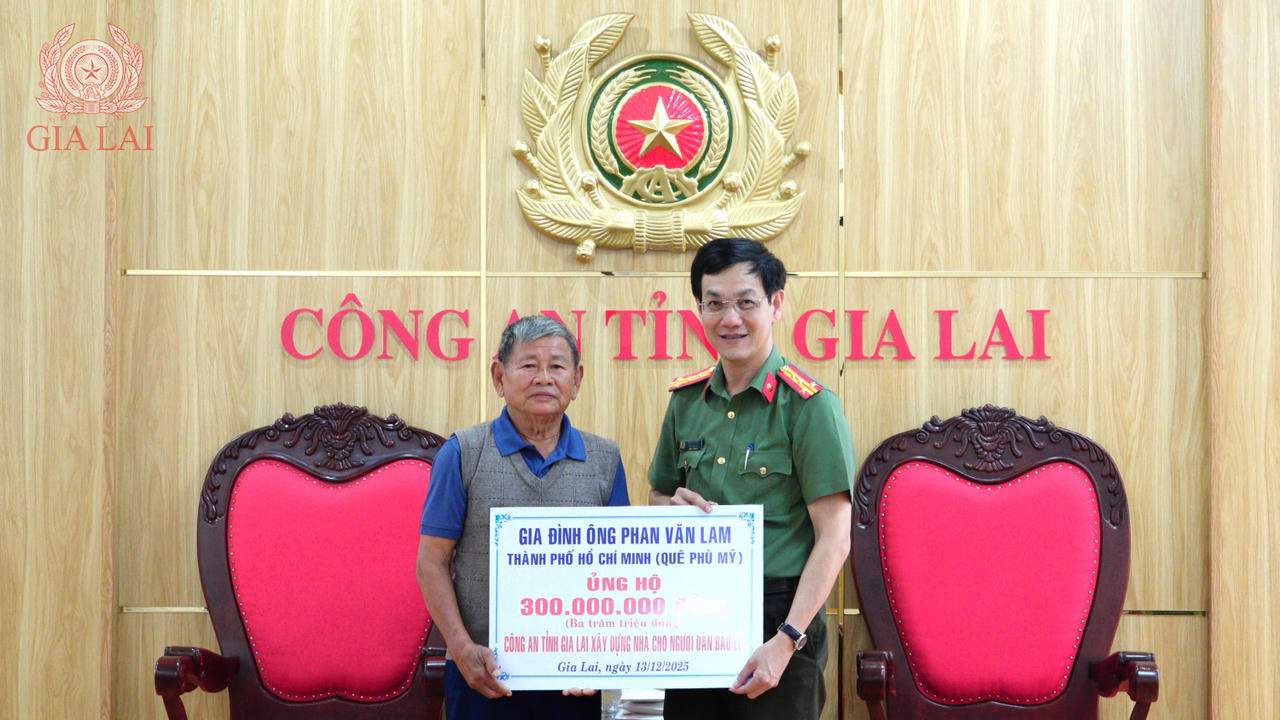 Ông Phan Văn Lam trao số tiền 300 triệu đồng cho Đại tá Ngô Cựu Vinh, Phó Giám đốc Công an tỉnh Gia Lai để hỗ trợ xây dựng nhà ở cho người dân vùng lũ. (Ảnh: Công an tỉnh Gia Lai)