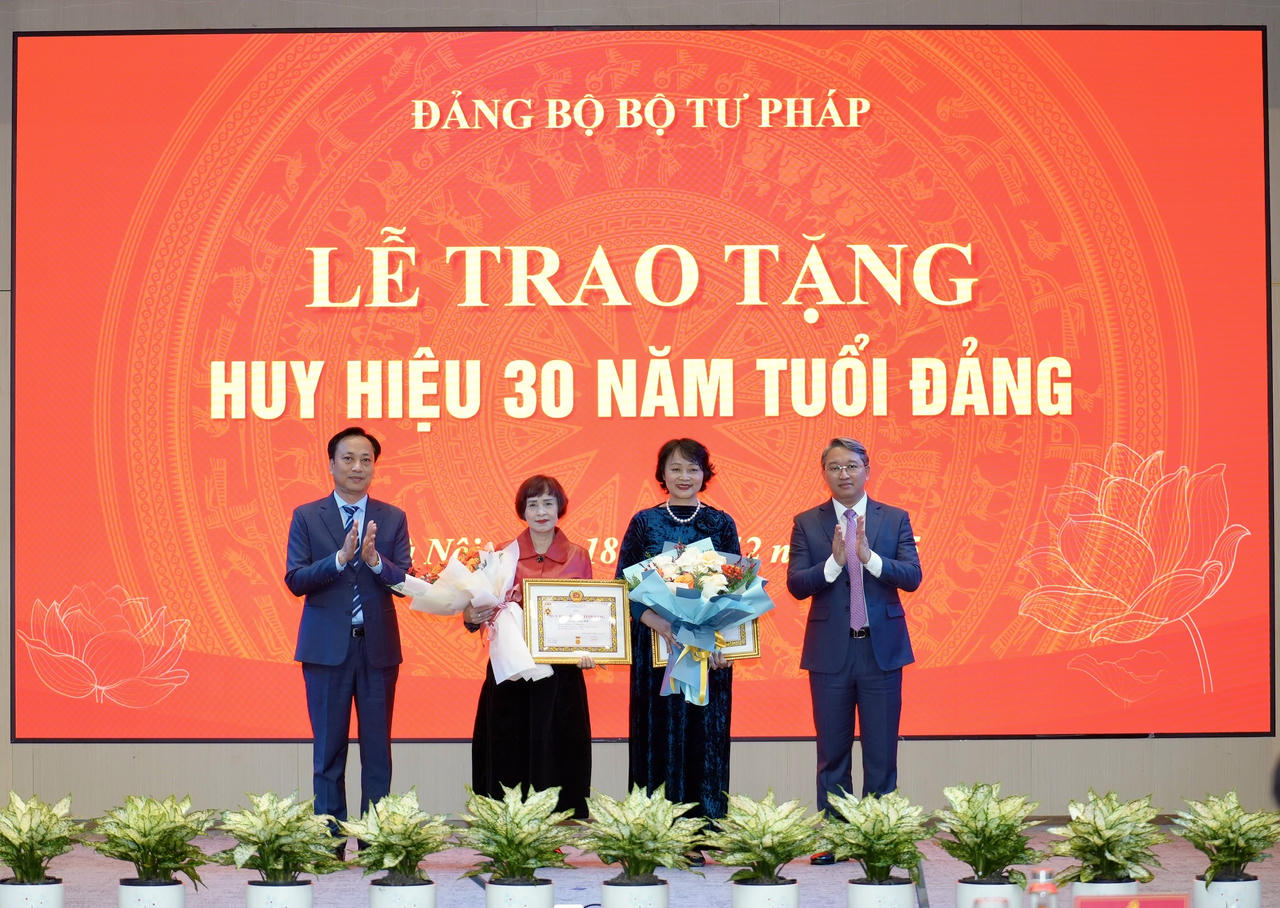 Bộ trưởng Nguyễn Hải Ninh và Đồng chí Lại Xuân Lâm, Phó Bí thư Đảng uỷ Chính phủ&nbsp;trao tặng Huy hiệu 30 năm tuổi Đảng cho đồng chí Khương Thị Thanh Huyền, Lê Mai Anh