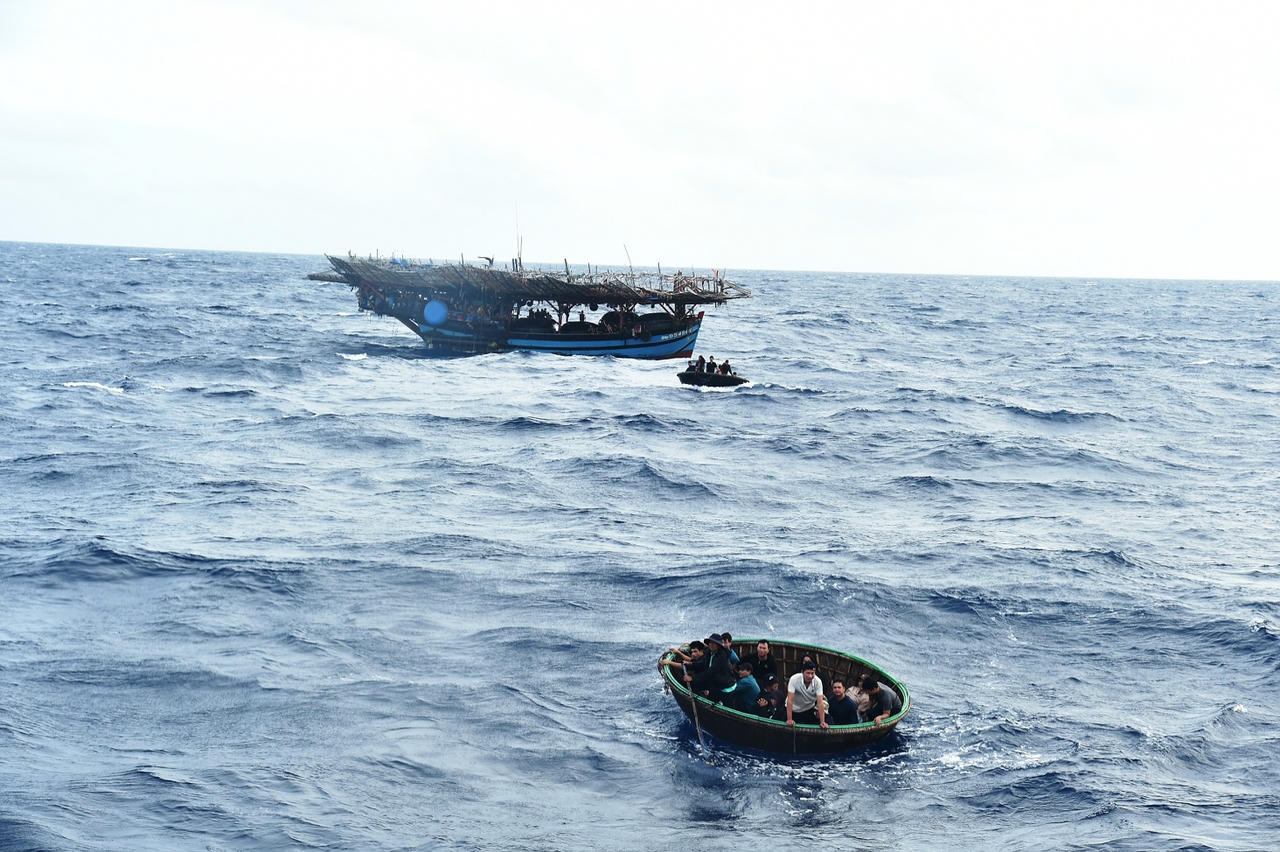 Các ngư dân di chuyển từ từ tàu cá sang tàu 364&nbsp;Bộ Tư lệnh Vùng Cảnh sát biển 2.