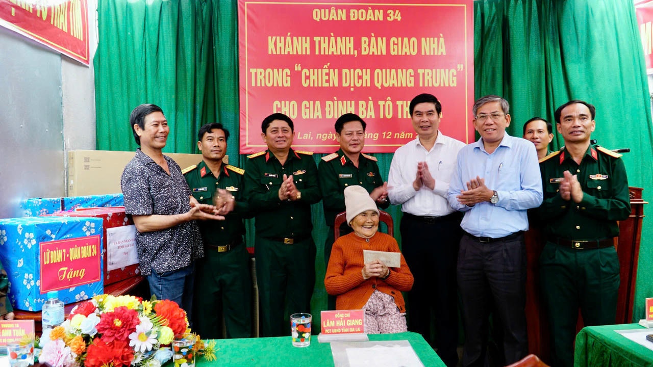Thiếu tướng Nguyễn Trần Long, Phó chính ủy Quân đoàn 34 (thứ 4 từ trái qua) cùng lãnh đạo tỉnh Gia Lai và chính quyền địa phương trao quà cho gia đình bà Tô Thị Sửa.