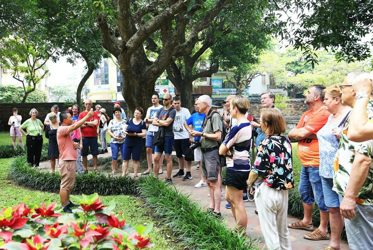 Hướng dẫn du khách quốc tế tham quan Văn Miếu - Quốc Tử Giám. (Ảnh: Nguyễn Quang)