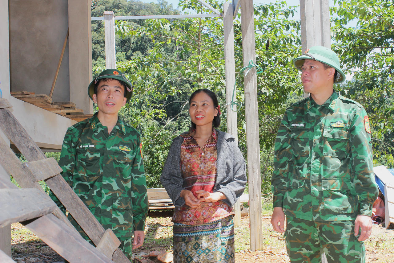 Trung tá Nguyễn Hà Giang (thứ nhất bên phải), Đồn trưởng Đồn Biên phòng Bản Giàng, kiểm tra quá trình xây dựng nhà ở cho người dân bản Giàng 2 (xã Hương Xuân).
