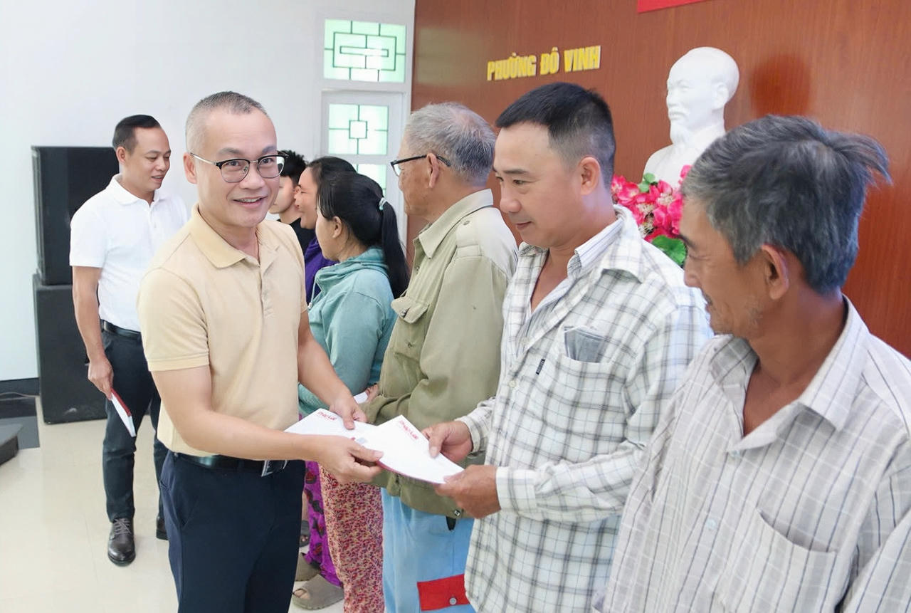 Nhà báo Trần Ngọc Hà – Phó Tổng Biên tập Báo PLVN trao quà cho người dân phường Đô Vinh.