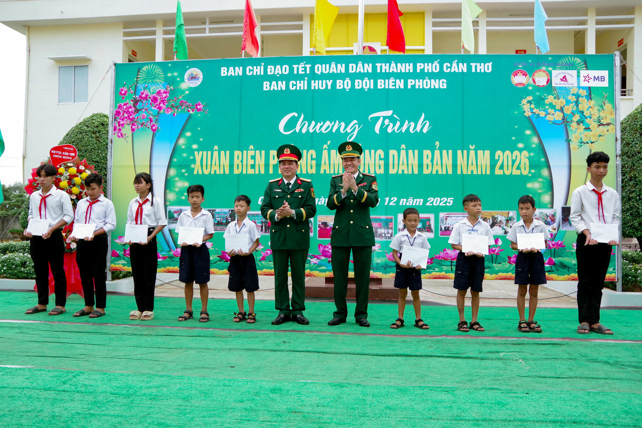 Đại tá Nguyễn Quốc Cường và Đại tá Phạm Ngọc Quang trao học bổng cho các em học sinh.