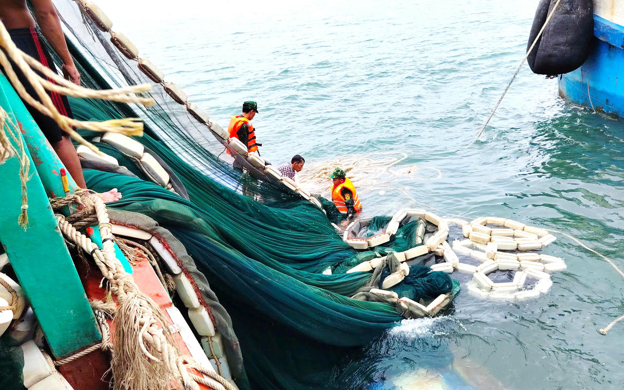 Cán bộ, chiến sĩ Đồn Biên phòng Hòn Chuối hỗ trợ trục vớt lưới đánh cá đưa lên tàu cứu nạn.