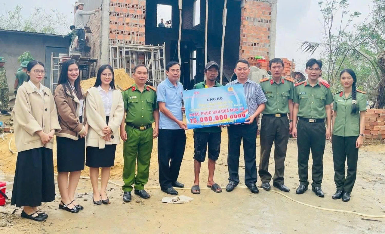 Thượng tá Nguyễn Quế Nhung và ông Phạm Minh Vỹ, Phó Giám đốc Công ty TNHH Hải Giang Bình Định trao số tiền hỗ trợ 15 triệu đồng giúp người dân thôn Chánh Hội tái thiết nhà cửa sau bão lũ.