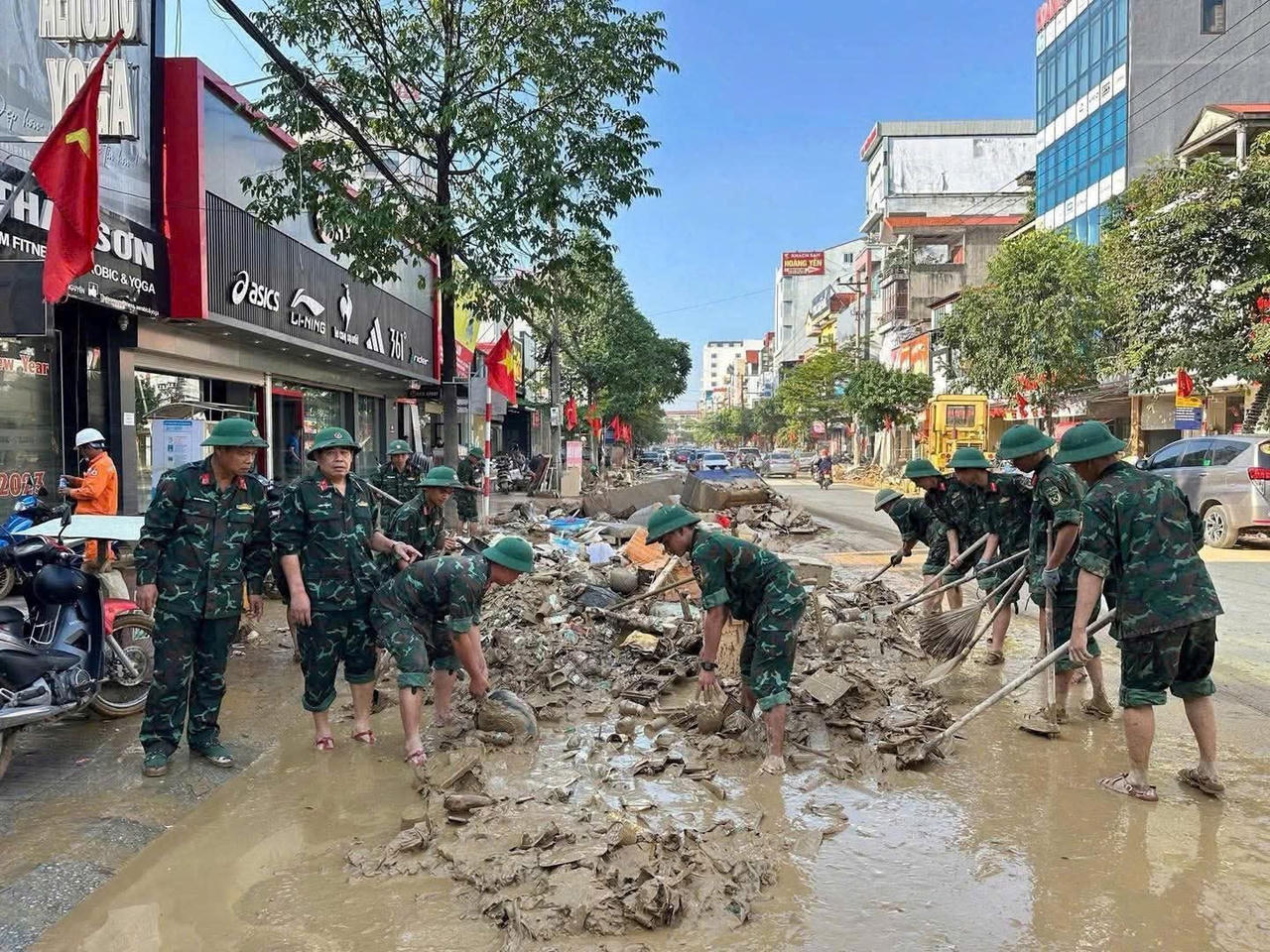 Bộ đội hỗ trợ nhân dân dọn dẹp, vệ sinh môi trường sau mưa lũ, ngập lụt.(Ảnh: PV)