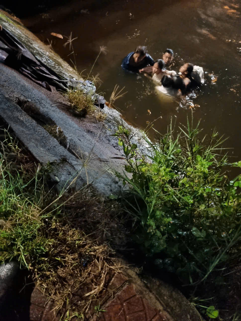Khoảnh khắc những người dân lao mình xuống dòng kênh trong đêm mưa lạnh, hợp sức đưa các nạn nhân lên bờ an toàn.