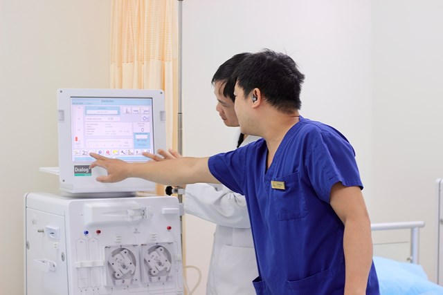 ThS.BSNT Mai Xuân Đạt (áo trắng) thao tác trên máy lọc máu.