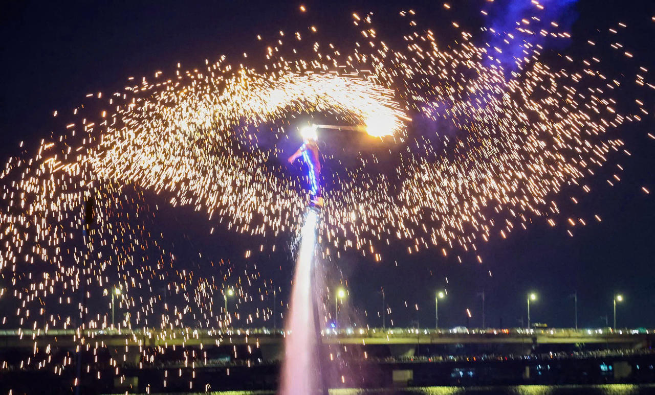 Khán giả thích thú theo dõi các vận động viên flyboard chuyên nghiệp trình diễn trong không gian ánh sáng rực rỡ, đầy ấn tượng.