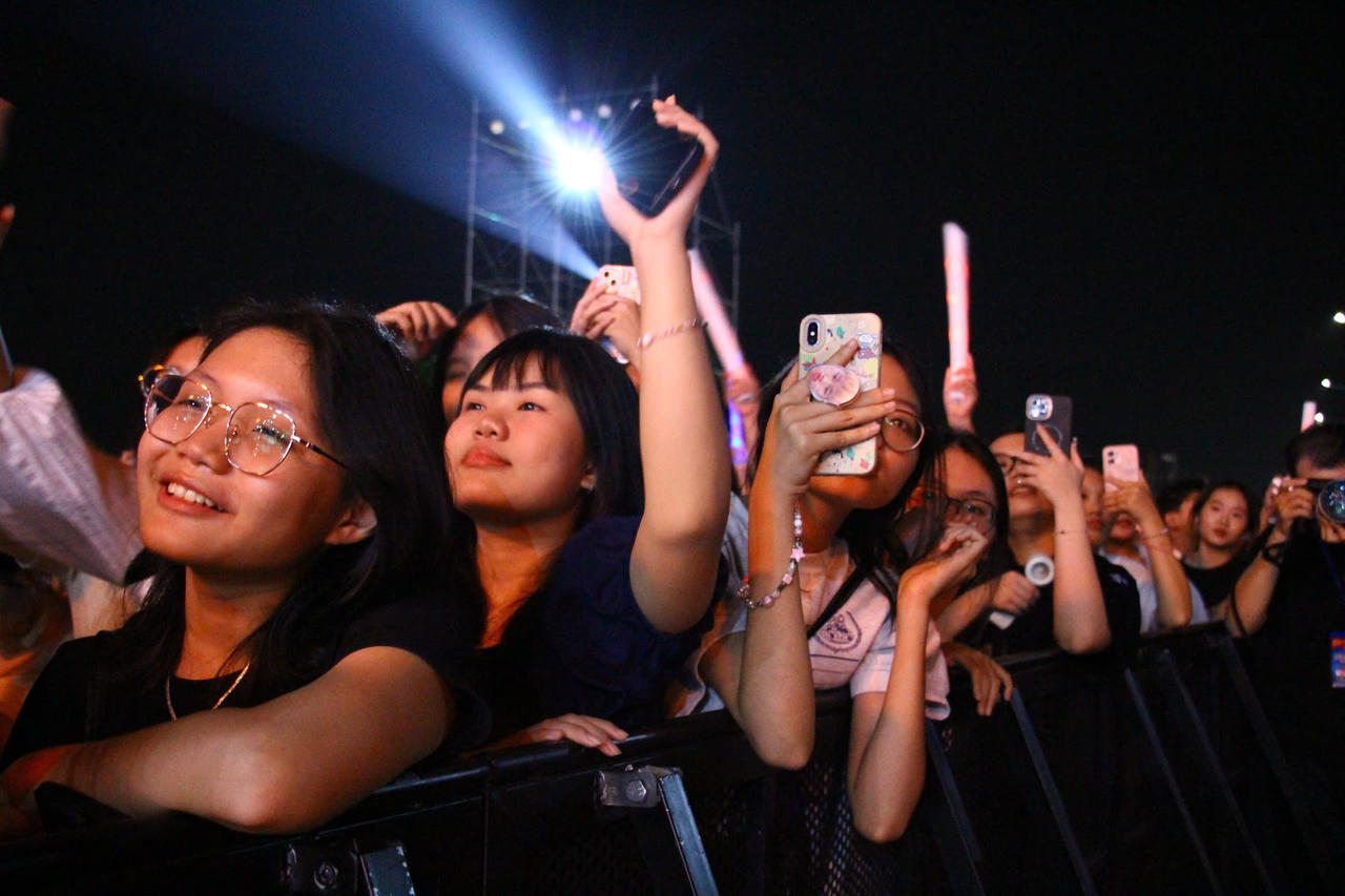 Nhóm bạn trẻ trên lối đi ven sông ghi lại những khoảnh khắc đáng nhớ cuối năm.