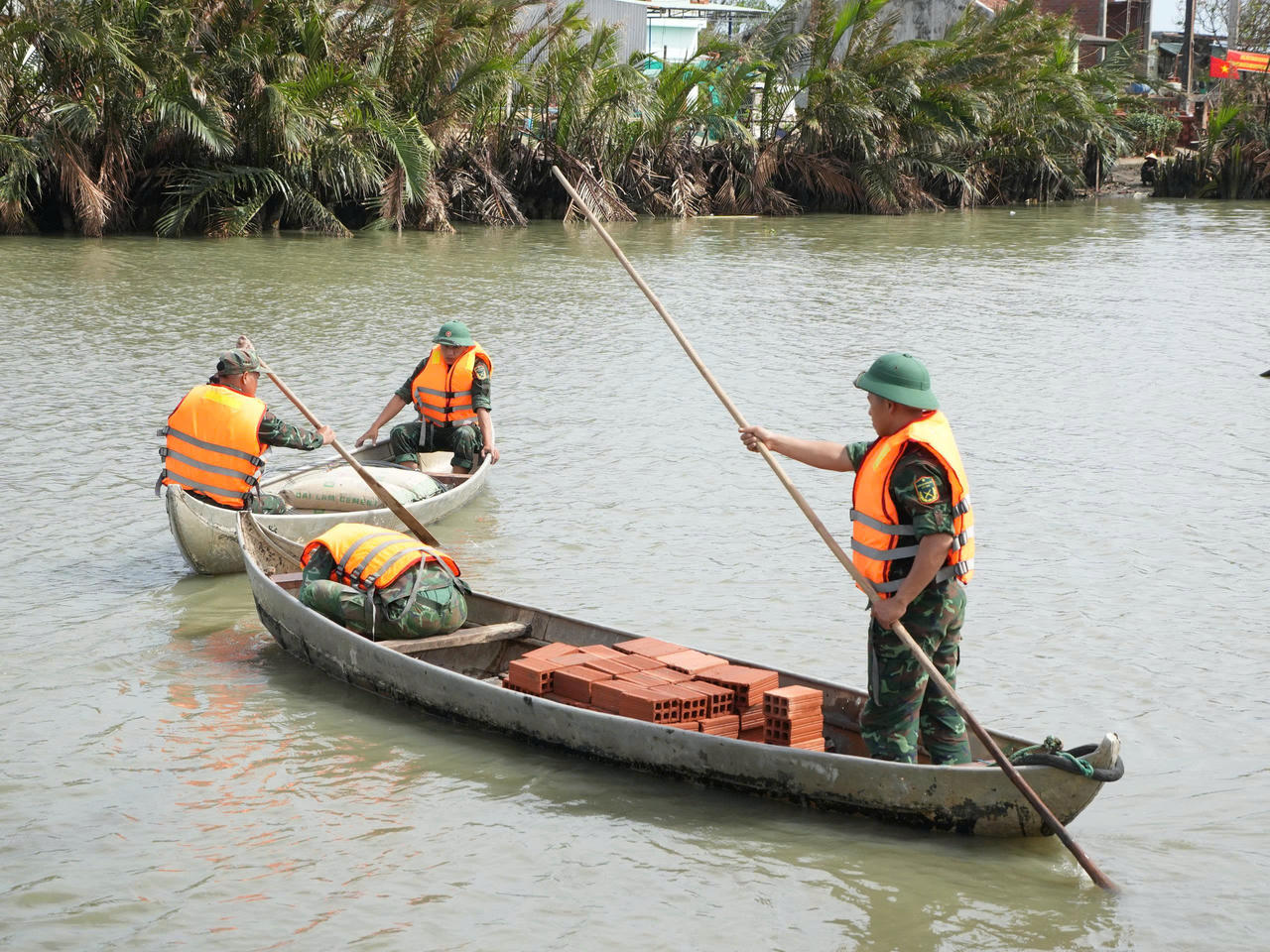 Cán bộ, chiến sĩ thuộc Trung đoàn 739 (Bộ Chỉ huy quân sự tỉnh Gia Lai) vận chuyển vật liệu bằng sõng giúp Nhân dân xây nhà ở xã Tuy Phước Đông, tỉnh Gia Lai.