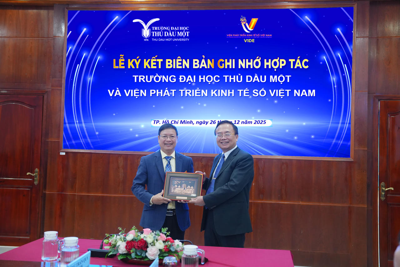 TS. Đoàn Ngọc Xuân – Hiệu trưởng trao quà lưu niệm của nhà trường đến TS. Trần Quý – Viện trưởng