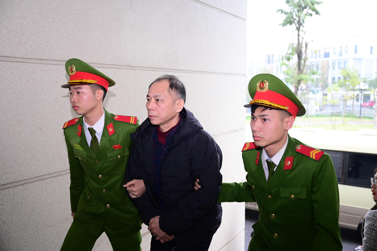 Dẫn giải bị cáo vào phòng xét xử.