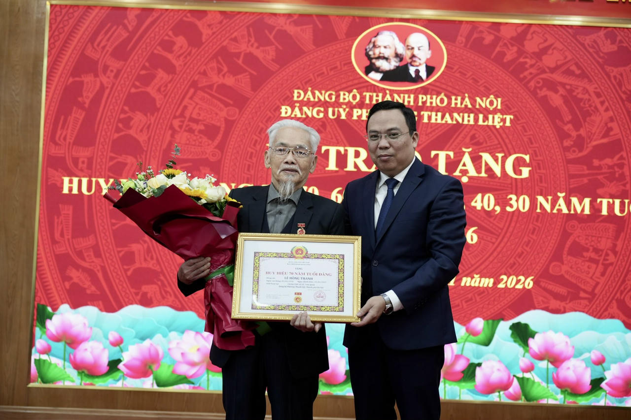 Đồng chí Nguyễn Minh Tuân trao Huy hiệu 75 năm tuổi Đảng cho đảng viên Lê Hồng Thanh. 