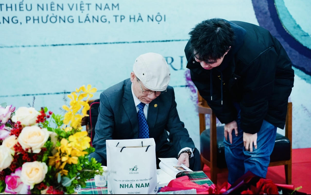 Thượng tá, bác sĩ Trần Ngọc Sơn - nguyên Phó Giám đốc Trung tâm Giám định Pháp y, Viện Khoa học hình sự, Bộ Công An ký sách tặng độc giả (ảnh M.Liên).