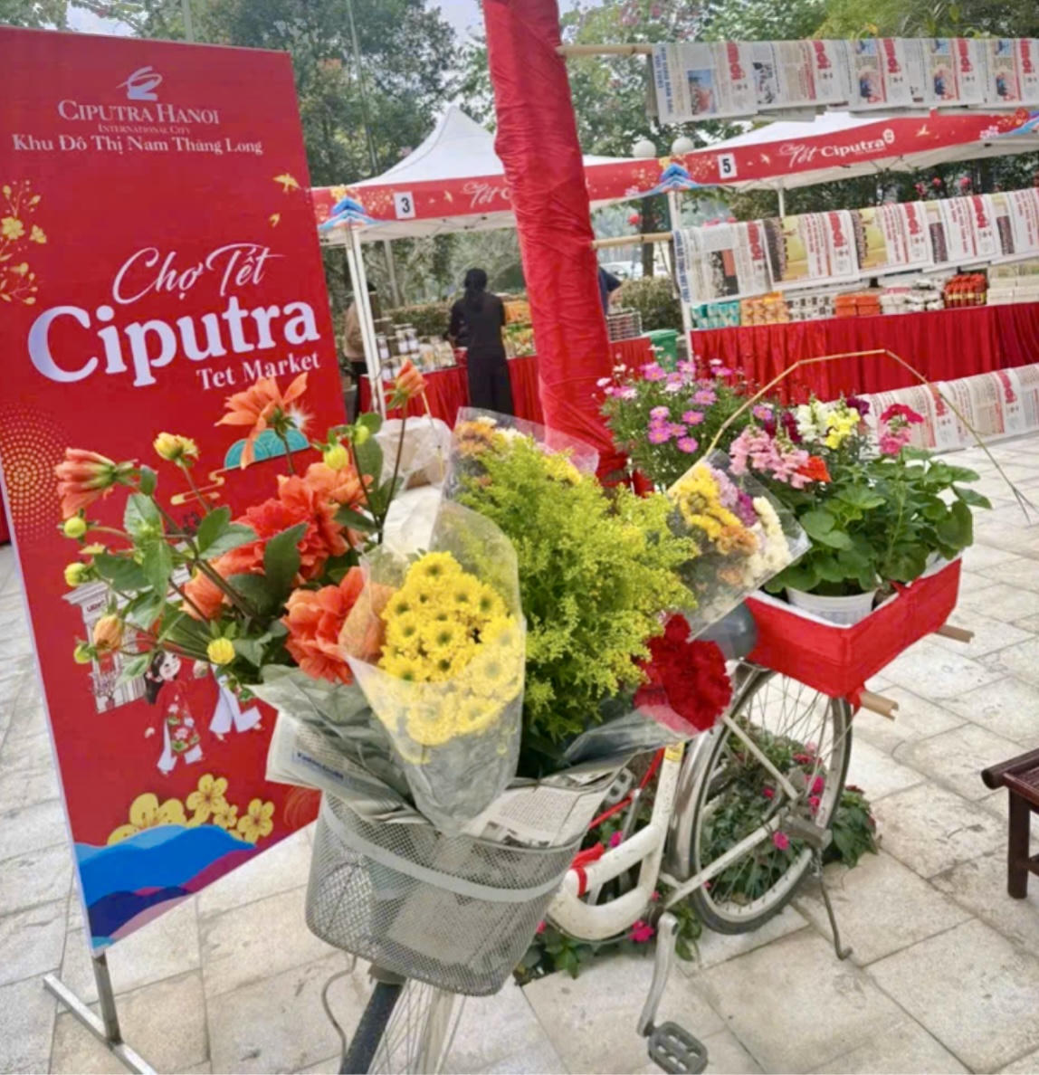 Không gian Chợ Tết Ciputra rực rỡ sắc xuân với xe hoa trang trí và các gian hàng truyền thống, tái hiện hình ảnh Tết Việt giữa khu đô thị hiện đại.