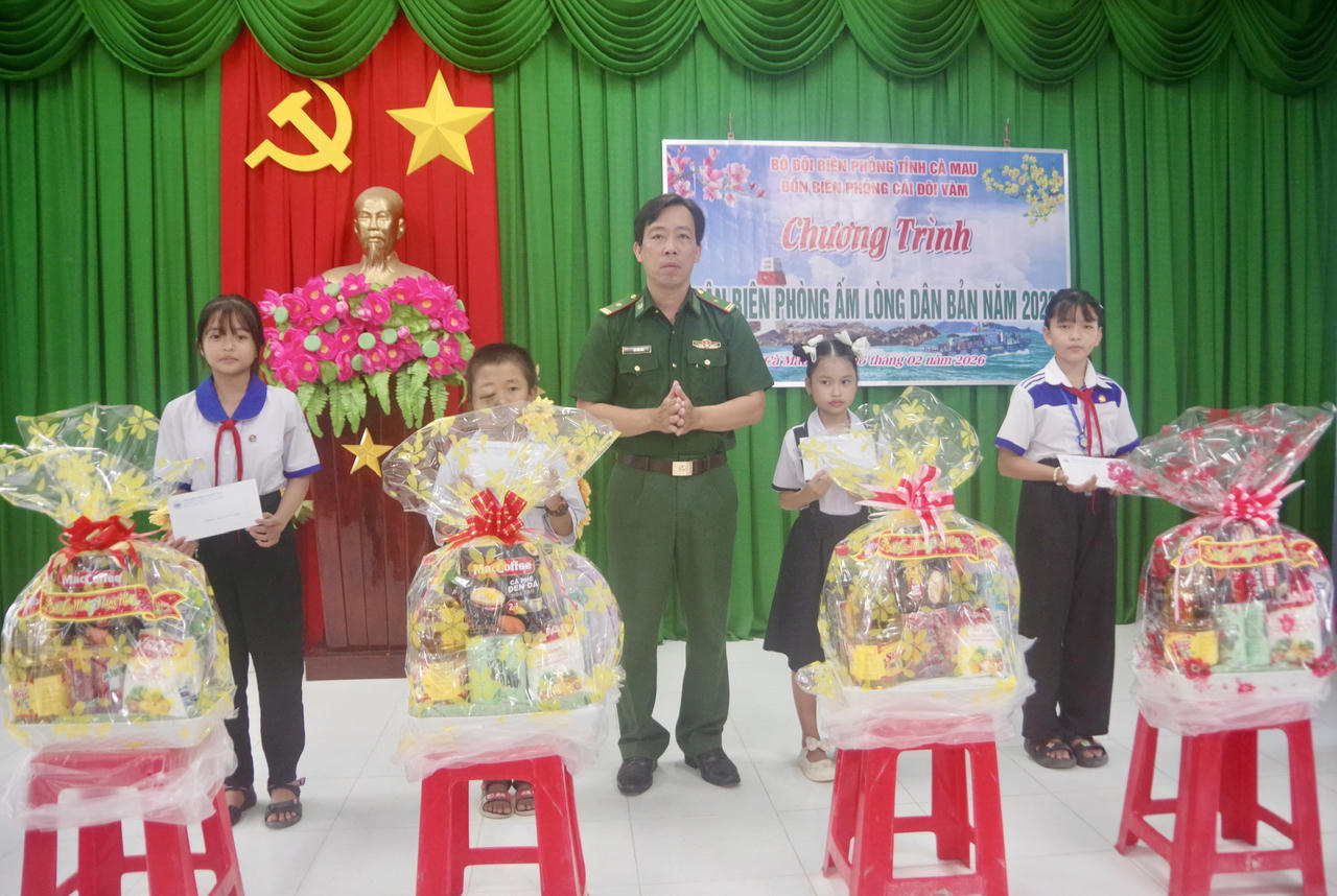 Thiếu tá Bùi Văn Hào - Bí thư Đảng ủy, Chính trị viên Đồn Biên phòng Cái Đôi Vàm trao học bổng và quà cho các em học sinh trong Chương trình “Nâng bước em đến trường - Con nuôi Đồn Biên phòng”.