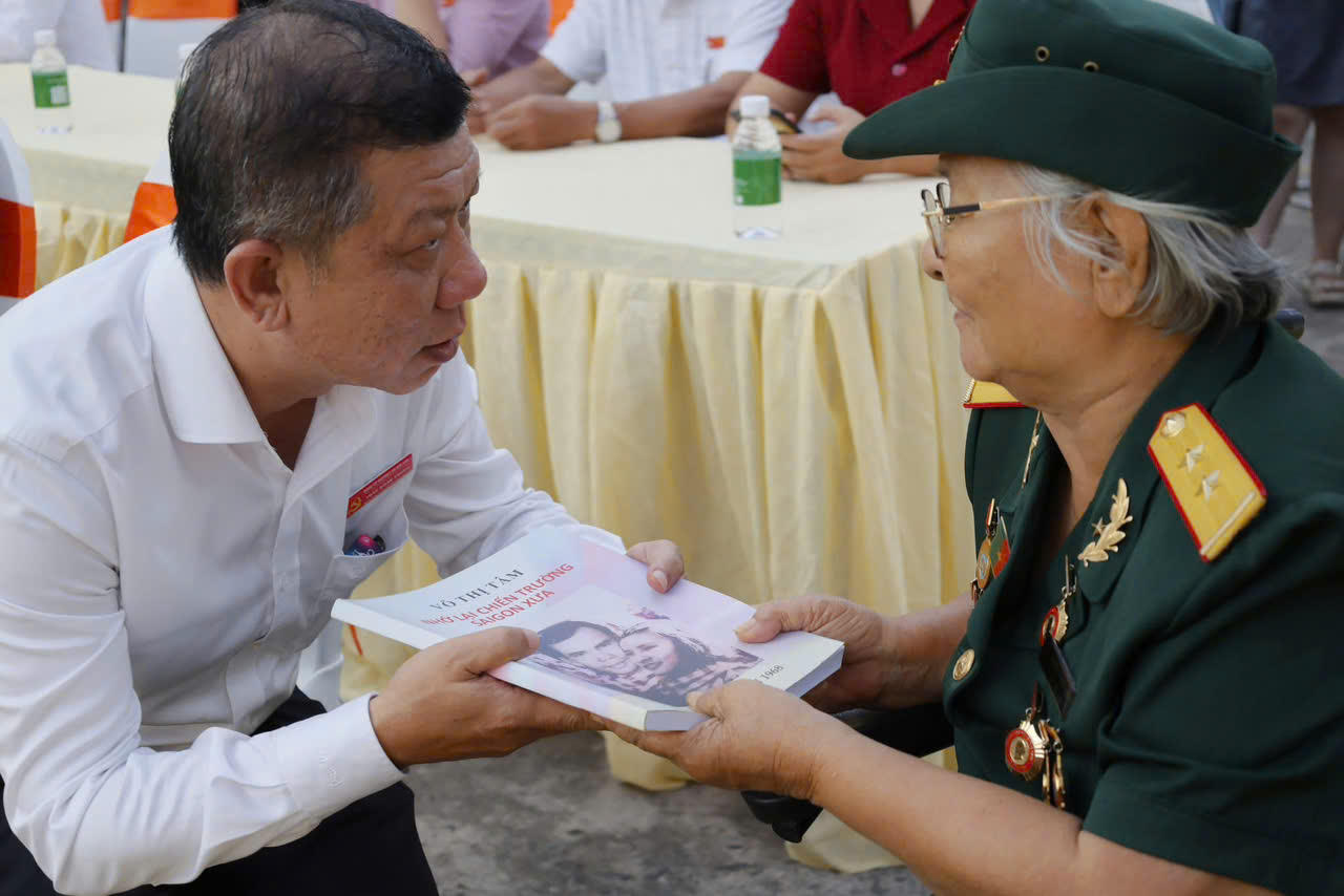 Ông Trần Đoàn Trung - Bí thư Đảng Ủy - Chủ Tịch HĐND phường An Hội Tây tặng sách cho Anh hùng LLVTND Võ Thị Tâm (Ảnh: UBND phường An Hội Tây).