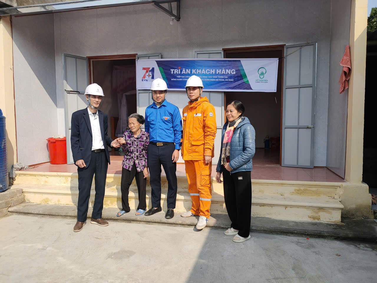 Nhân viên Công ty Điện lực Ninh Bình hỗ trợ kéo dây dẫn cho gia đình có hoàn cảnh khó khăn là gia đình bà Trần Thị Duật ở Thôn 6, Vũ Bản, xã Bình Giang.