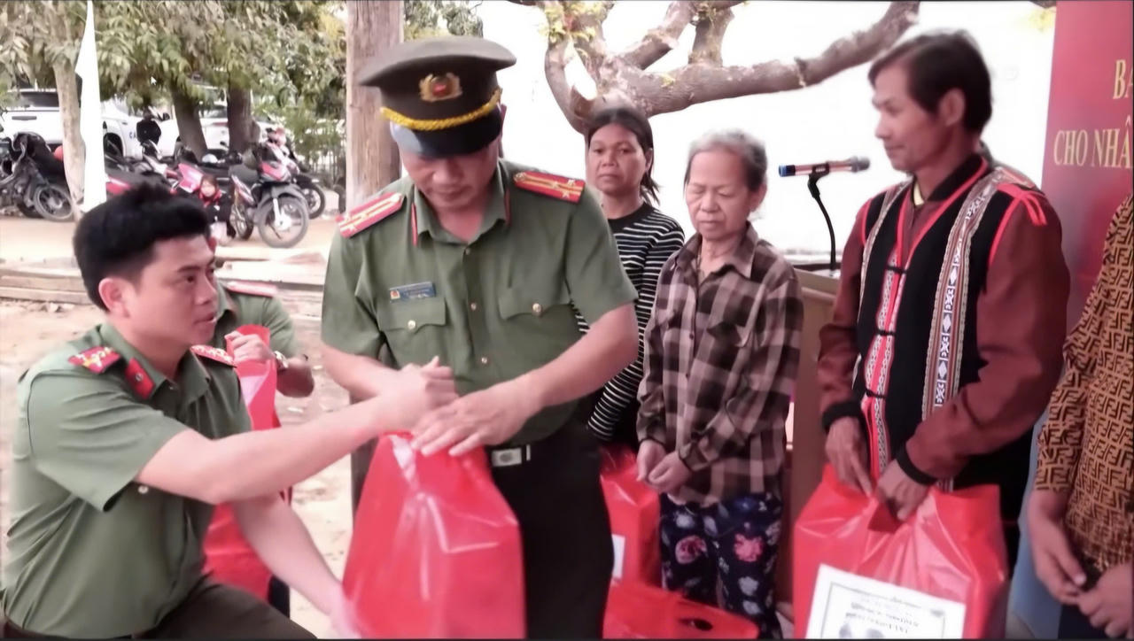Các chiến sĩ Công an ân cần trao tận tay những phần quà Tết nghĩa tình cho bà con.