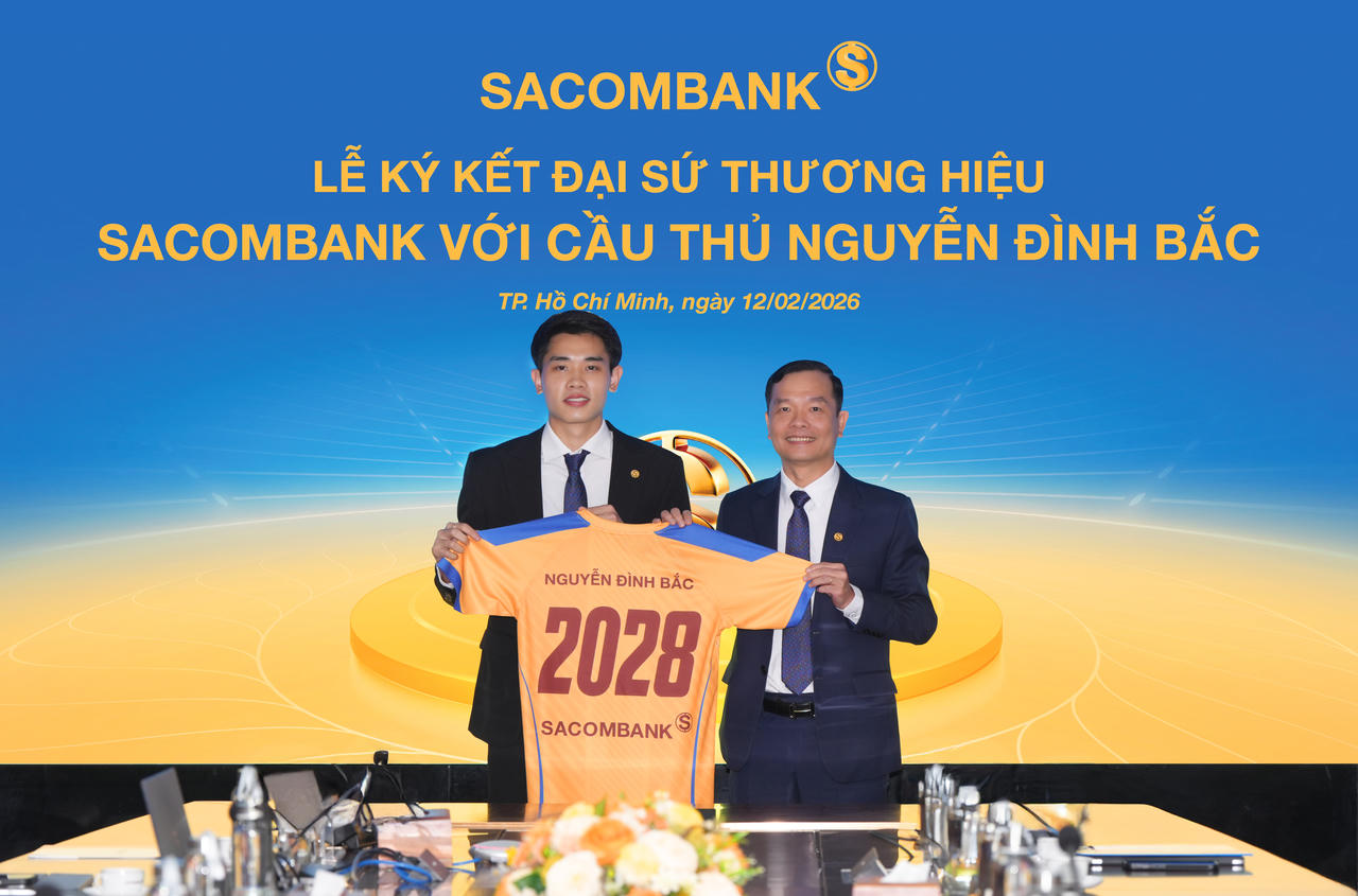 Ông Hà Văn Trung - Phó Tổng giám đốc thường trực Sacombank trao trang phục cho Đại sứ thương hiệu Nguyễn Đình Bắc tại buổi lễ ký kết.