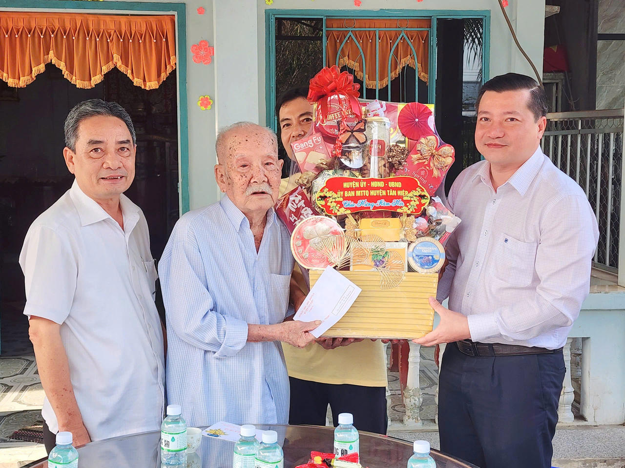 Ông Đinh Xuân Phương – Bí thư Đảng ủy xã Tân Hiệp tặng quà cho gia đình chính sách