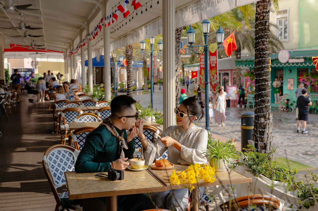 Khói ấm của thức ăn hòa cùng tiếng cười rộn rã, sắc áo Tết của du khách năm châu làm sáng bừng khu chợ đêm như một phiên chợ xuân hiện đại.