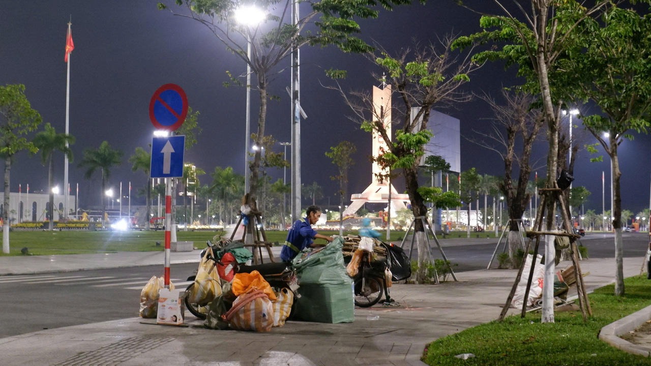 Tại khu vực Quảng trường 29/3, các công nhân môi trường miệt mài thu gom rác thải dù trời đã tối muộn.&nbsp;